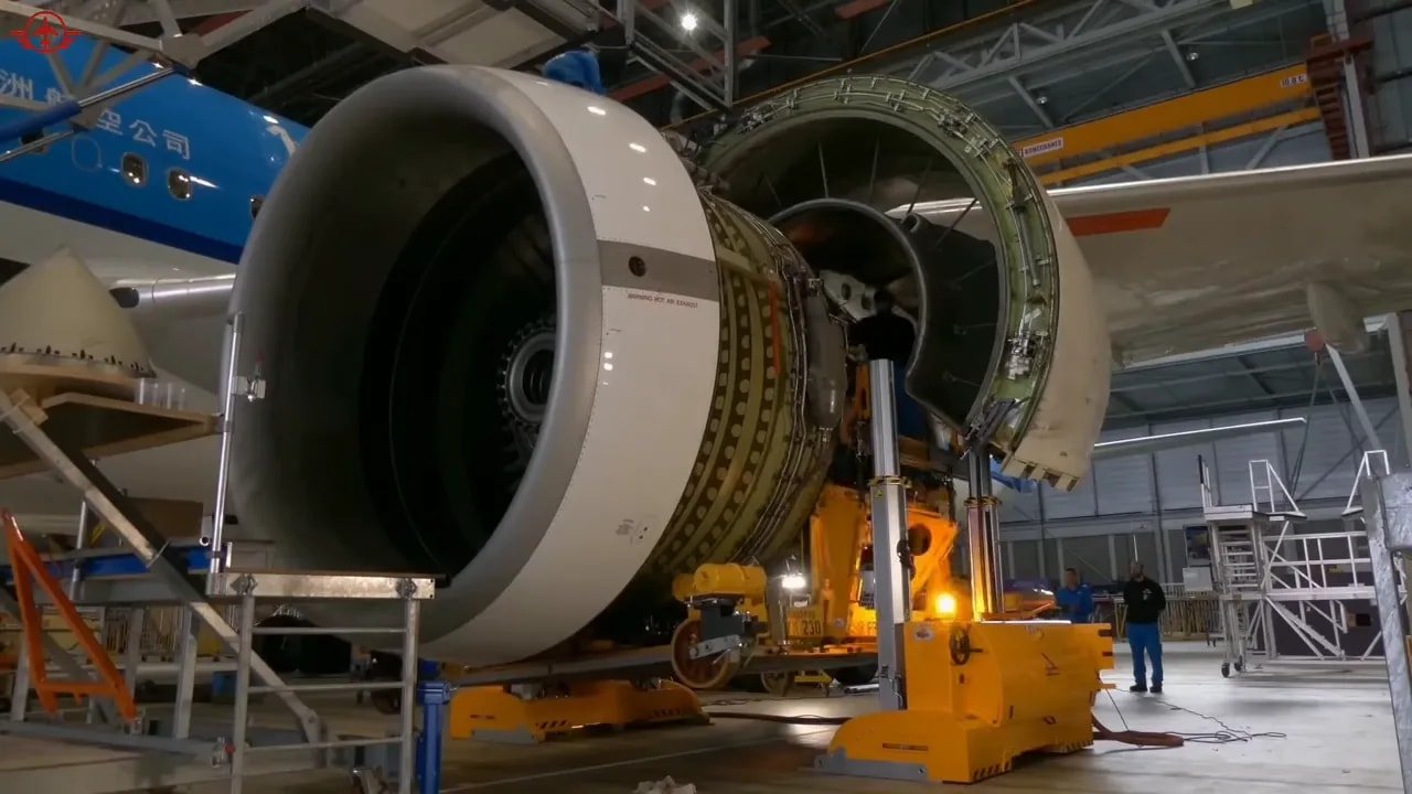 Large turbofan engine with open nacelle under assembly inside an industrial hangar