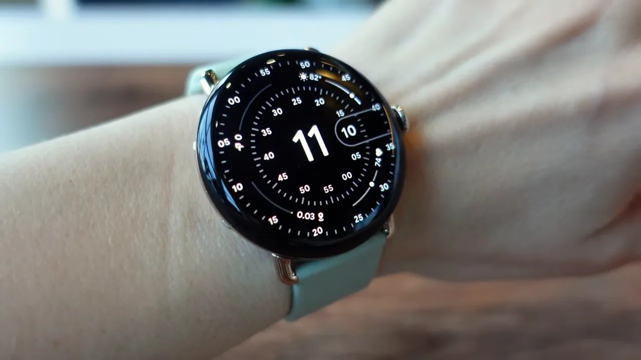 Close-up of round Pixel Watch on wrist showing detailed watch face